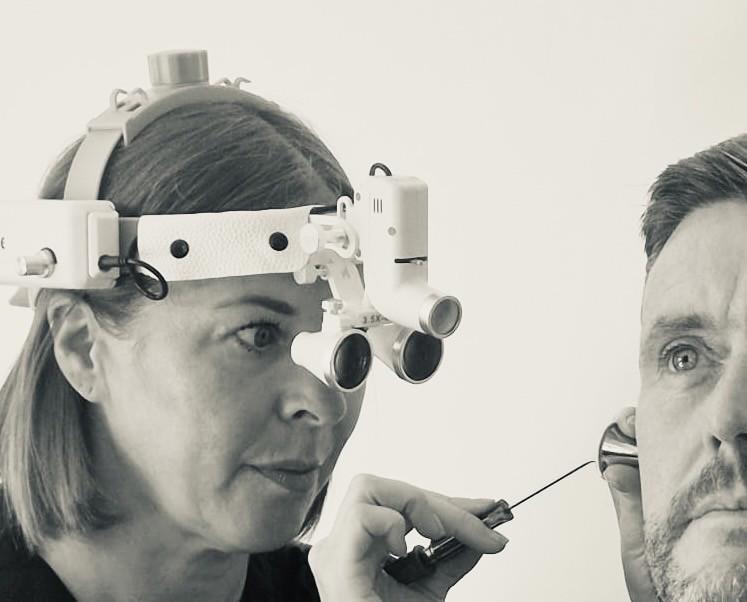 A person looking in someone's ear