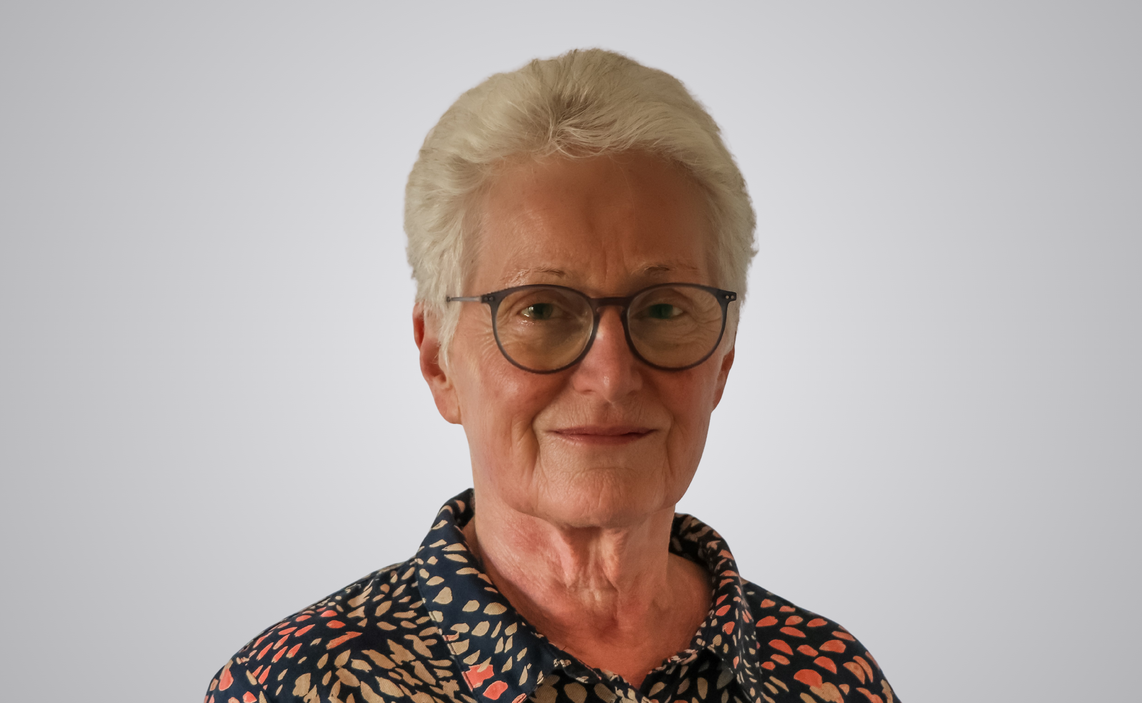 Kay Vowles is wearing glasses and smiling.