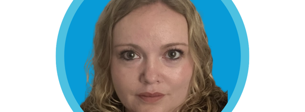 A blonde curly-haired woman is taking a selfie.