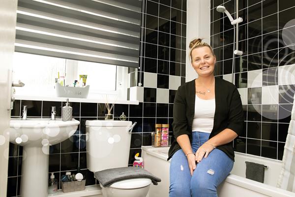 An Eastlight resident smiles in her bathroom