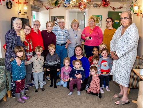 Residents of Oxley House, a housing scheme for over 55s, stand alongside nursey children and Eastlight staff.