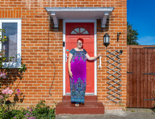 A resident standing outside her front door