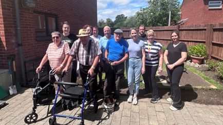 Residents and Eastlight staff members stood in a communal garden.