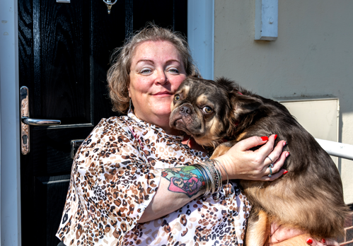 Eastlight resident, Tammy, with her dog sitting on her front doorstep.
