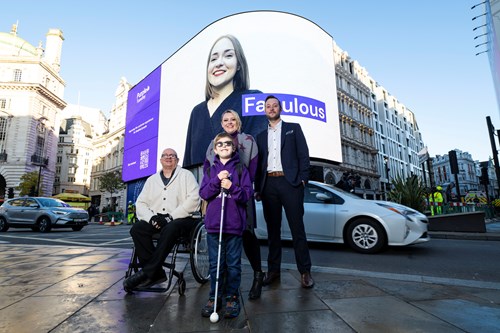 From left to right: CIC members, Craig Clackett, Michelle Baker, Michelle's son and Eastlight EDI Manager, Hugo Drummond. The group is standing in front of a Purple Tuesday billboard displaying the word 'Fabulous' at Piccadilly Circus, London