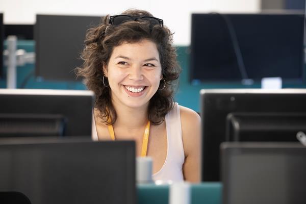 Eastlight staff member smiling at her desk and computer