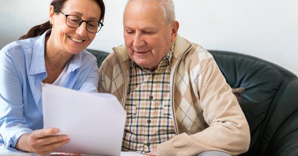 Elderly man talking about paperwork with a woman