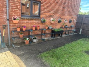 A row of newly constructed planters lined up along a brick wall