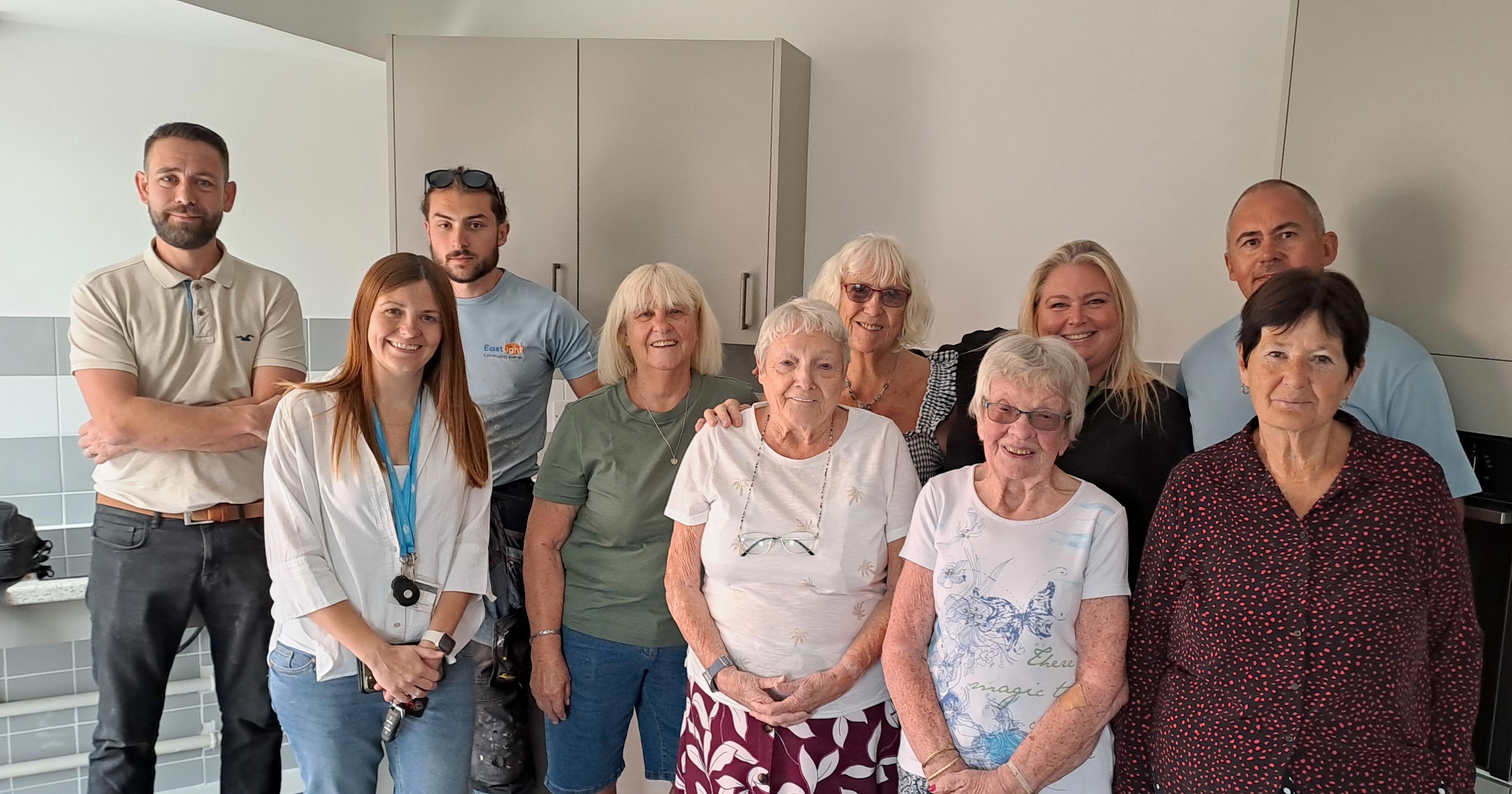 Eastlight staff and residents at Mulberries stood together in the new communal kitchen.
