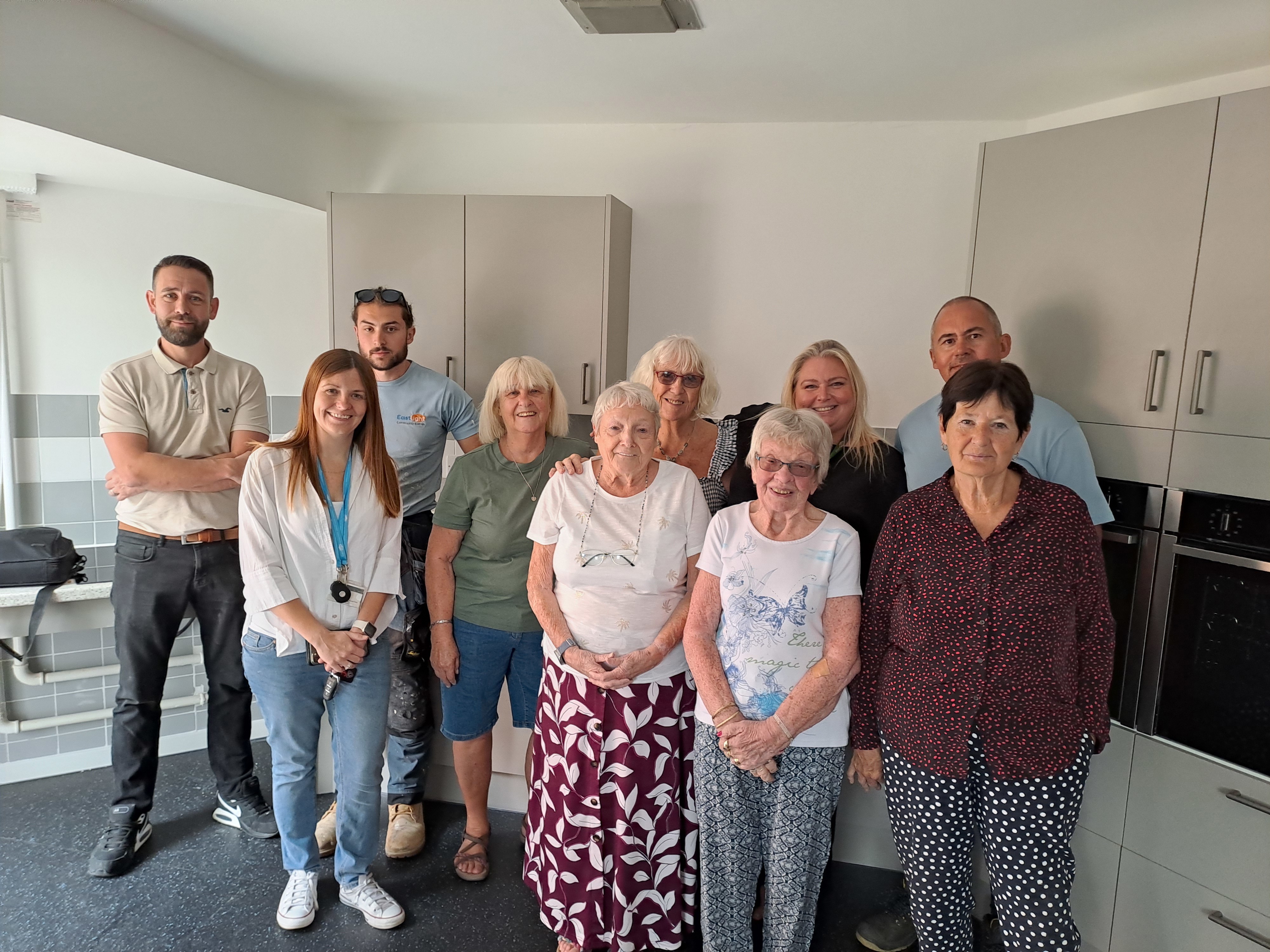 Eastlight staff and residents at Mulberries stood together in the new communal kitchen.