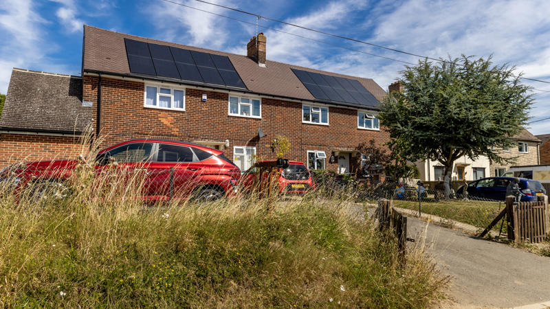 Two houses with solar panels on them.