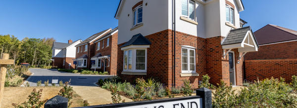 A newly built Eastlight home at the Dickens End development, featuring a red-brick and cream exterior, landscaped gardens and neighbouring homes nearby.