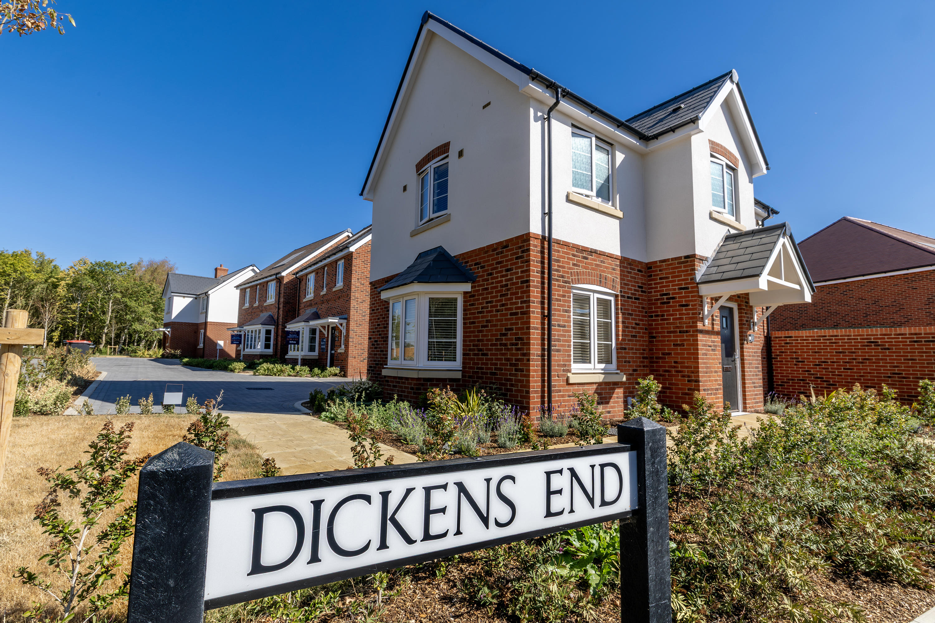 A newly built Eastlight home at the Dickens End development, featuring a red-brick and cream exterior, landscaped gardens and neighbouring homes nearby.