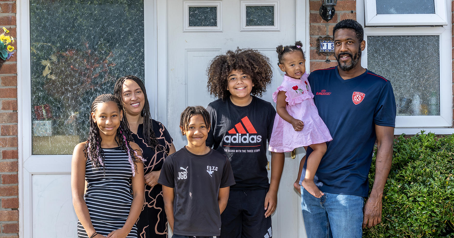 Eastlight resident Sheeren, her partner and four children are stood at the front of their house, in front of their front door.