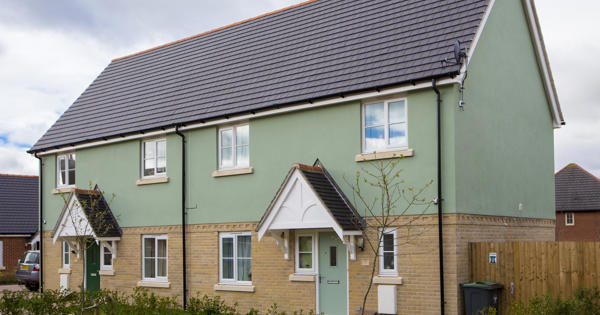 Two semi-detached houses. The bottom half of the houses have light-brown brick, and the top half is painted light-green. 