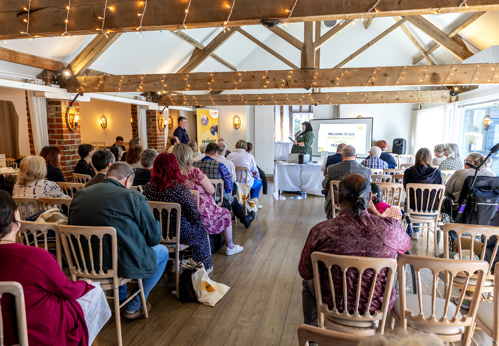 Eastlight residents watching a presentation during the event. The photo is taken from the back of the room, behind the residents.