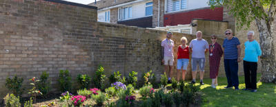 ERG Witham members are stood next to a newly installed flower bed.