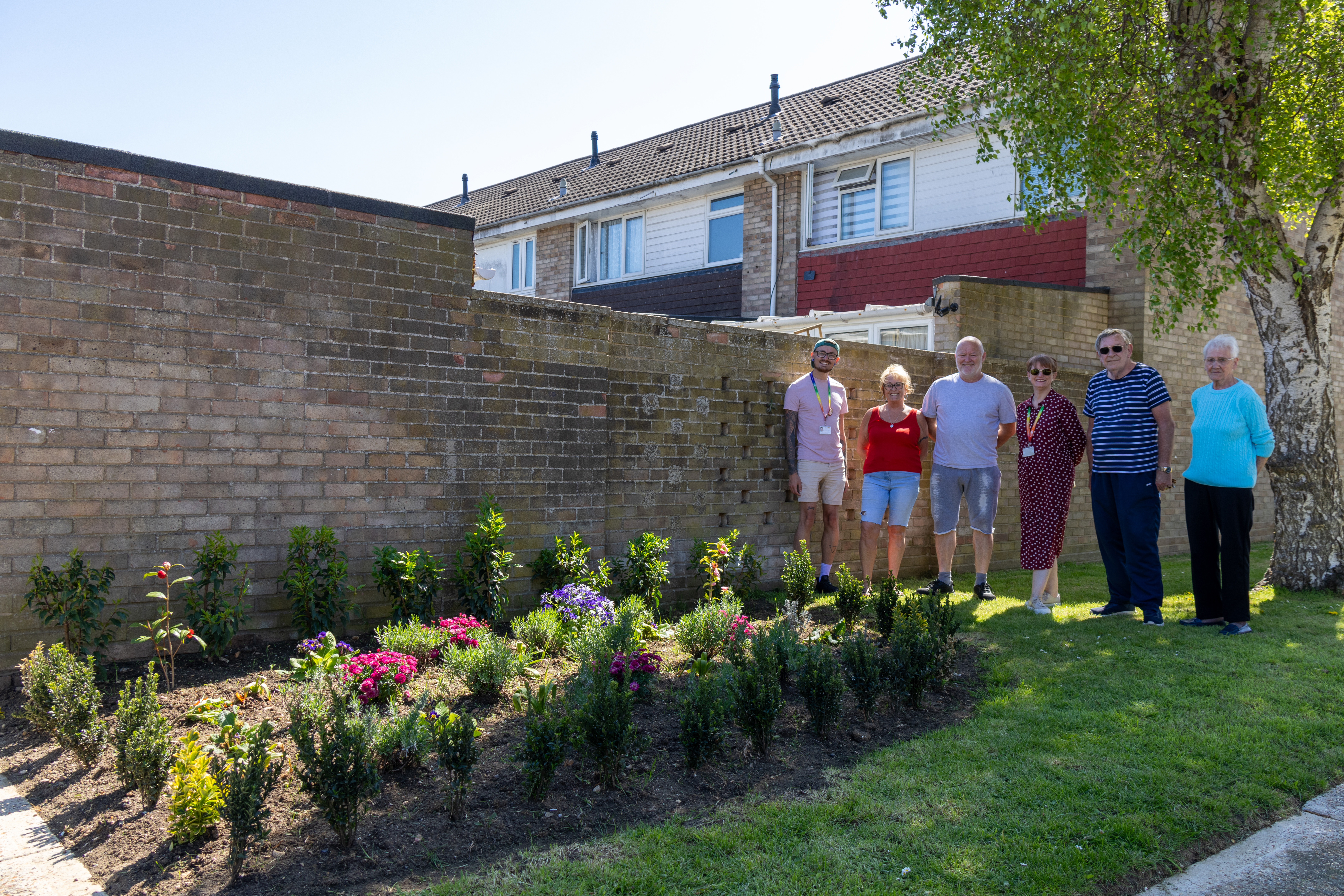 ERG Witham members are stood next to a newly installed flower bed.