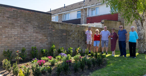 ERG Witham members are stood next to a newly installed flower bed.
