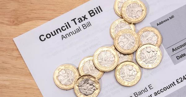 A paper Council Tax Bill (Annual Bill) with pound coins on top