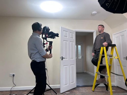 Roy being filmed in an Eastlight home whilst on step-ladder