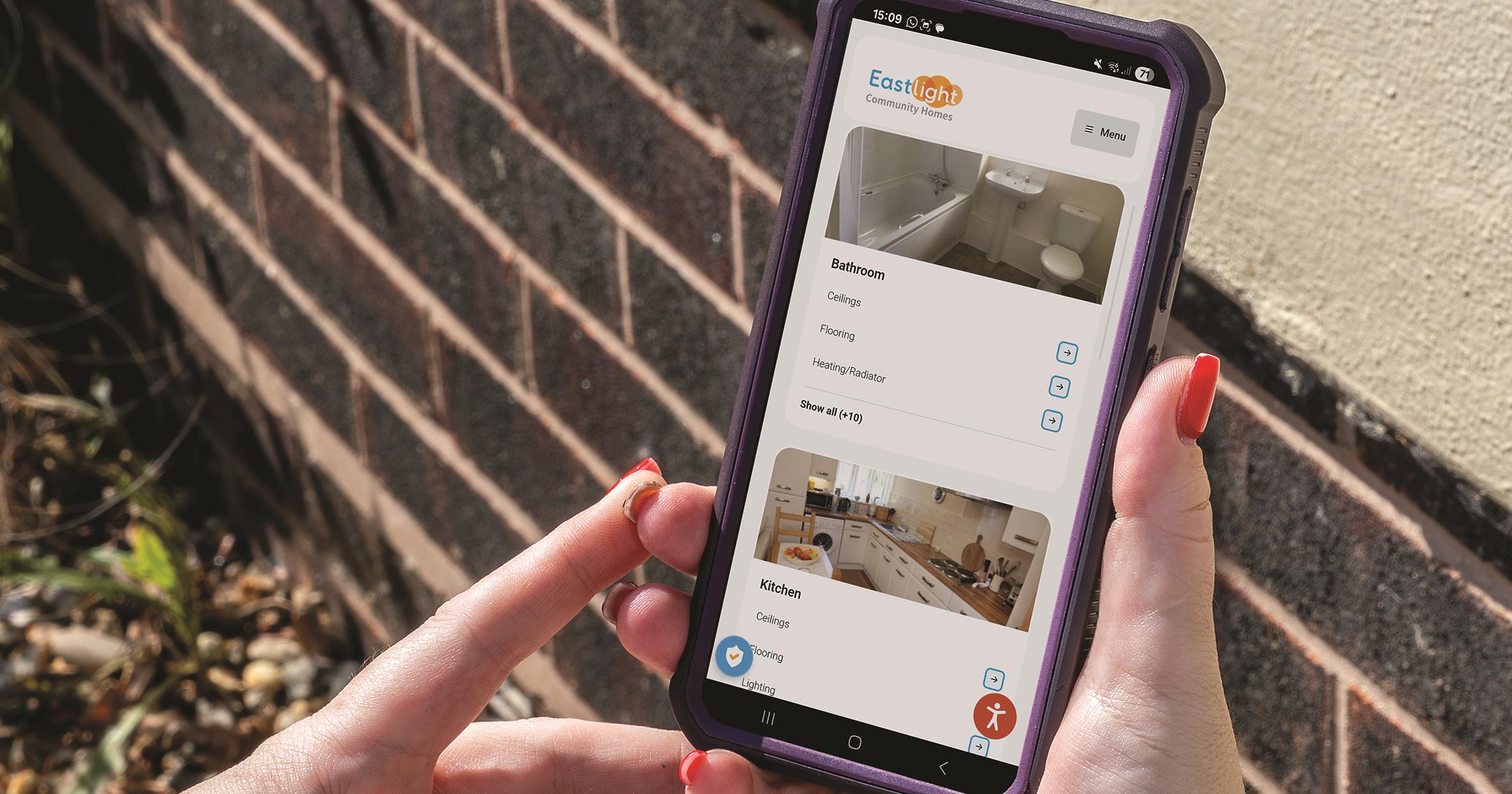 Two hands are holding a mobile phone which shows the My Eastlight portal.