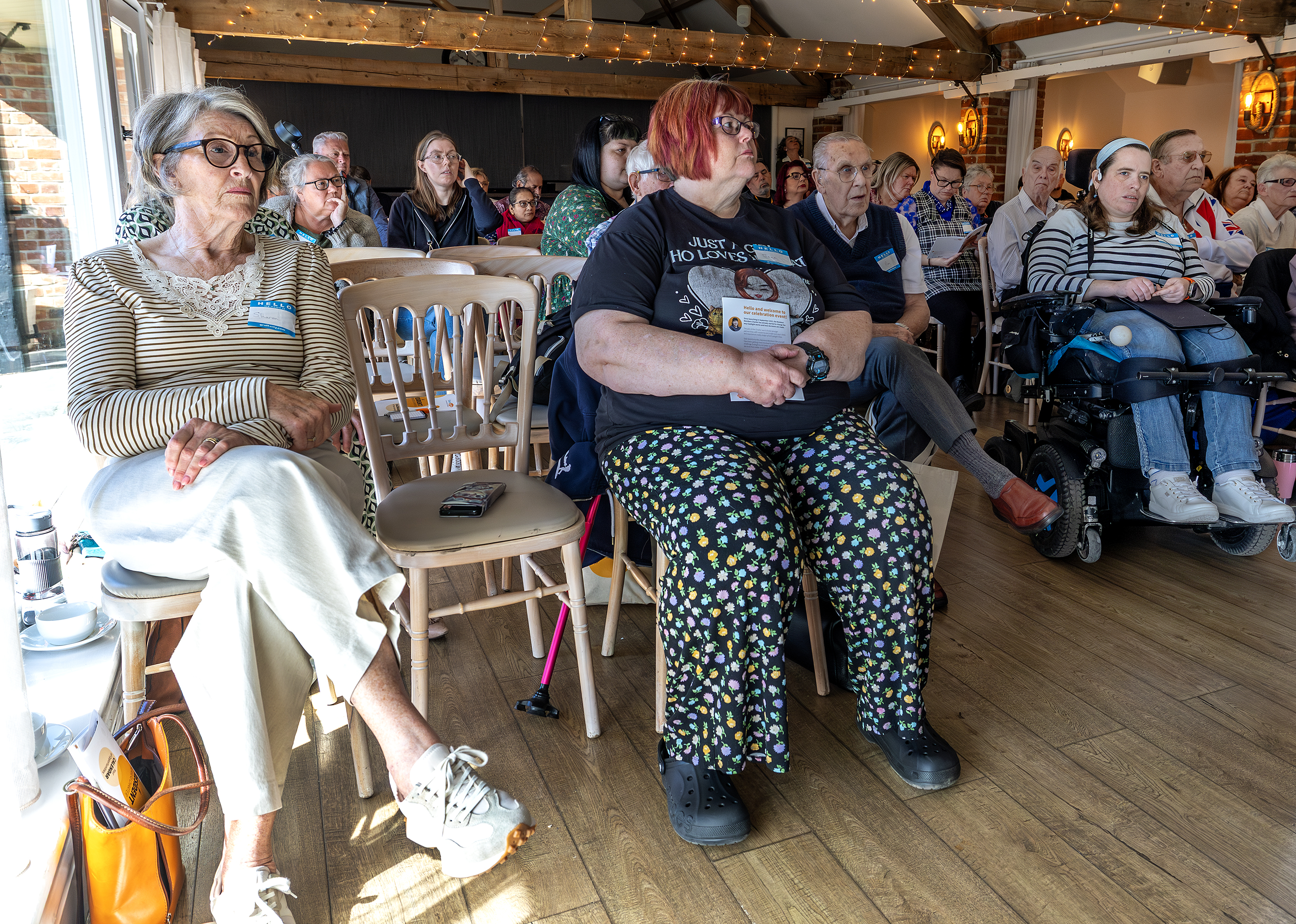 Audience members look towards the stage during a presentation at the Resident Members Charter celebration event, April 2026.