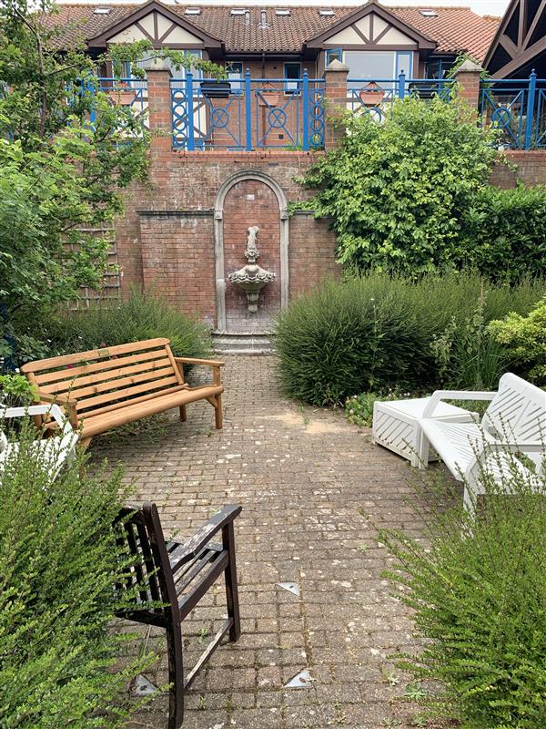 An outdoor garden with benches and a sculpture.