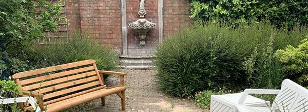 An outdoor garden with benches and a sculpture.