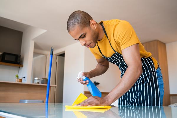 Man cleaning kitchen worksurface 