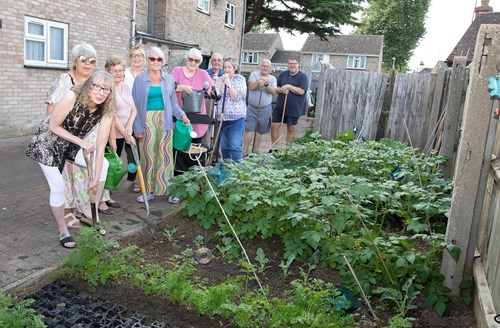Woodlands residents posing as a crowd behind their revamped community garden and allotment