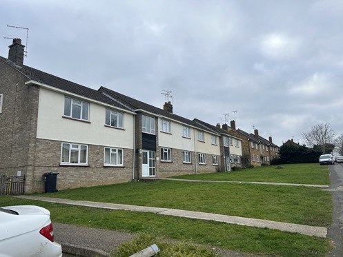 A row of blocks of flats with grassy areas in front.
