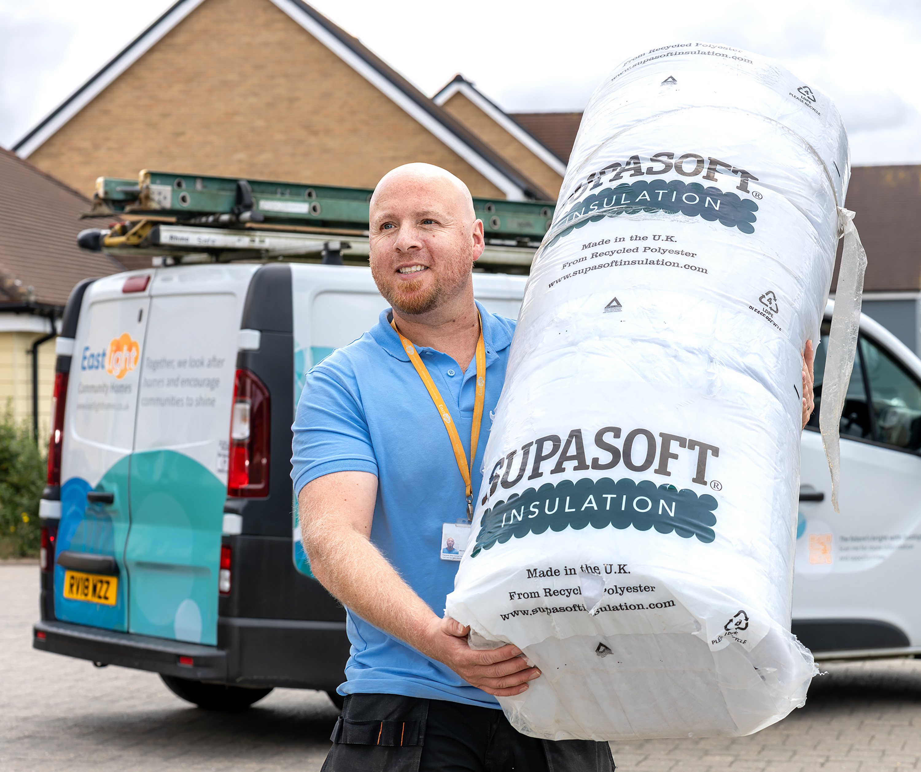 2.	A member of Eastlight Home Solutions  Team carrying a roll of loft insulation outside a resident's home as part of work to improve home warmth and energy efficiency.